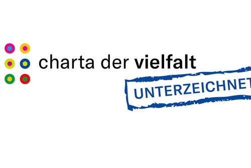 Charta der Vielfalt- Logo mit blauer/schwarzer Schrift, weißer Hintergrund und bunten Punkten.